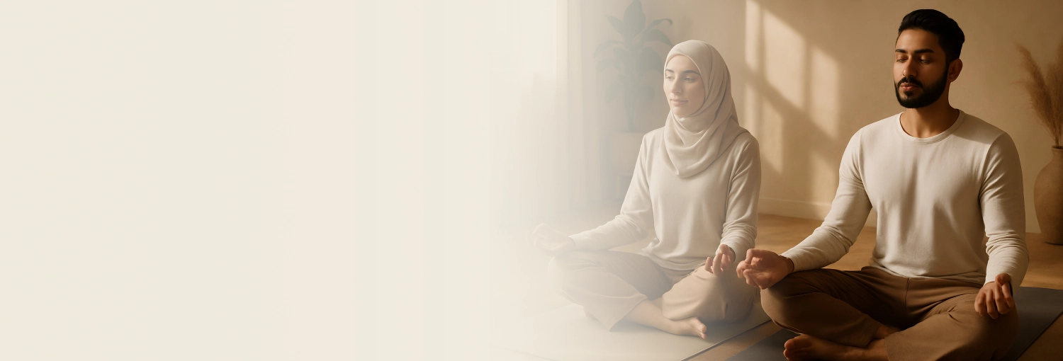 A group of people meditating indoor, sitting cross-legged with eyes closed