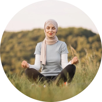 A smiling female with closed eyes meditating