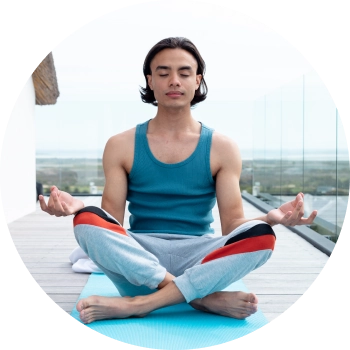 A teenage boy in sports wear, sitting in outdoor space and meditating in Shuni mudra