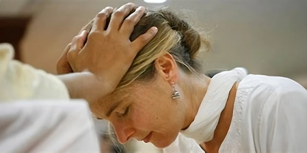 Person receiving healing energy during Art of Living Blessings program, showing moment of deep spiritual connection