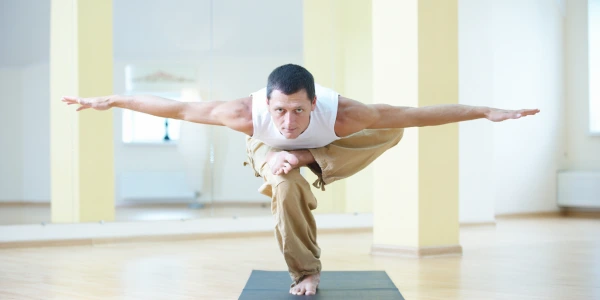 Man performing yoga A man practicing yoga in a bright room, symbolizing inner strength and self-discovery for all ages