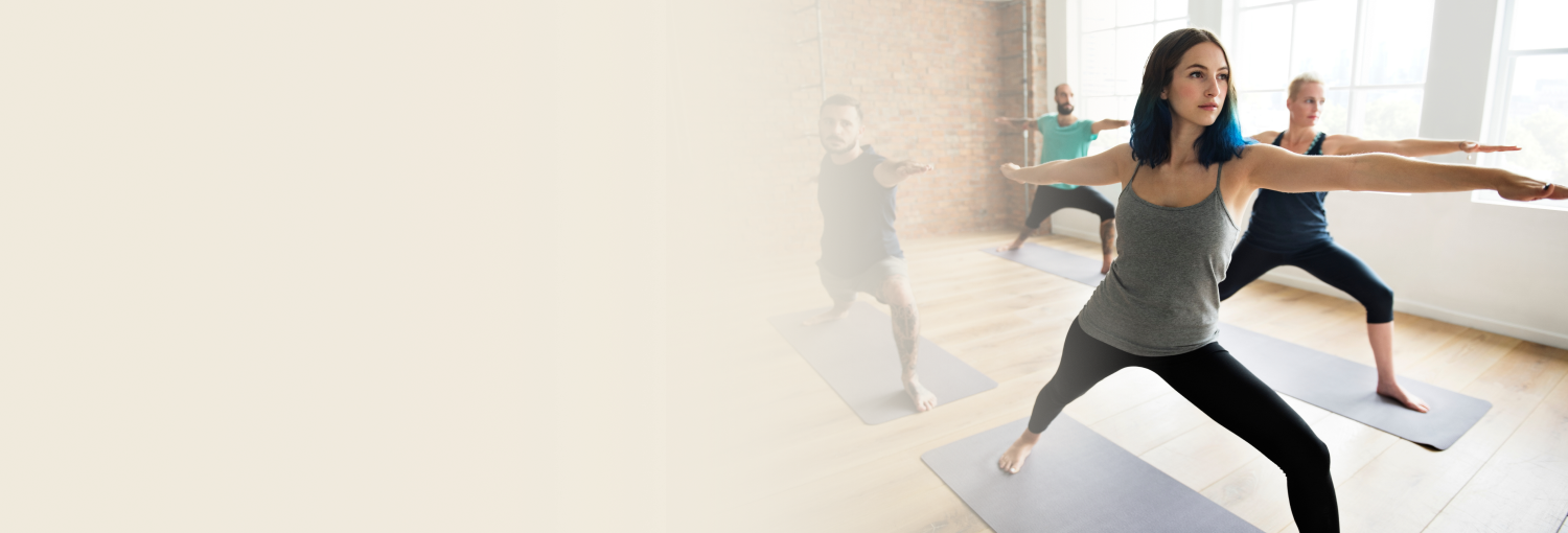 Students practicing warrior pose during Sri Sri Yoga class