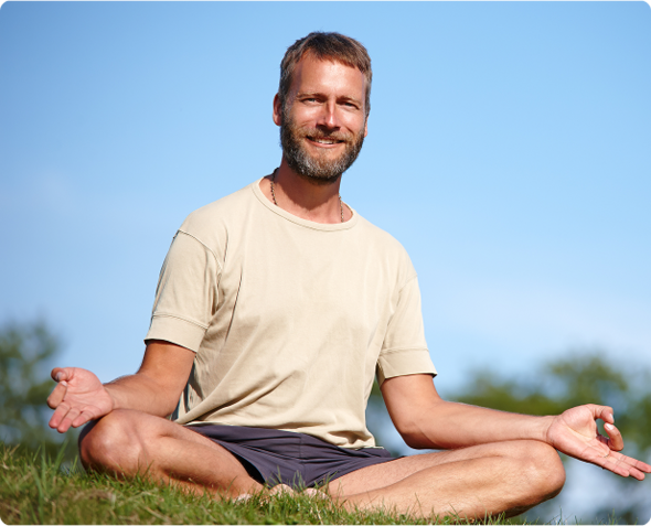 A man getting ready for meditation in a open lawn with chin mudra