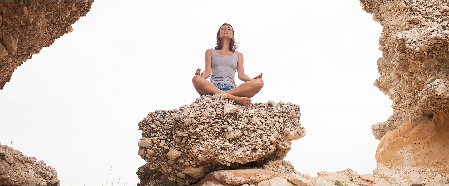 Women practicing meditation on yoga mats in sunny outdoor setting