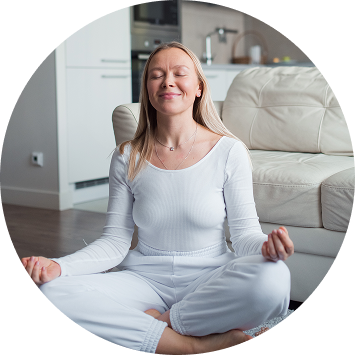 Woman in white sitting peacefully in lotus pose practicing sahaj meditation