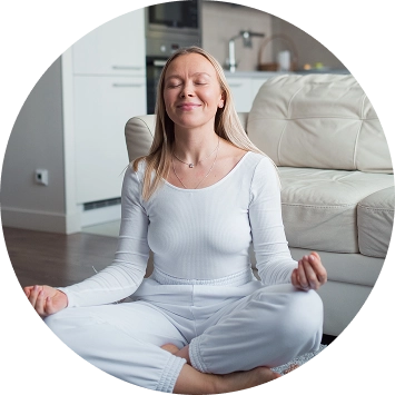 Woman in white sitting peacefully in lotus pose practicing sahaj meditation