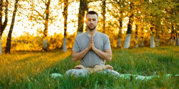 Practitioner in deep meditation pose during sunset, demonstrating advanced Sanyam practices for inner silence