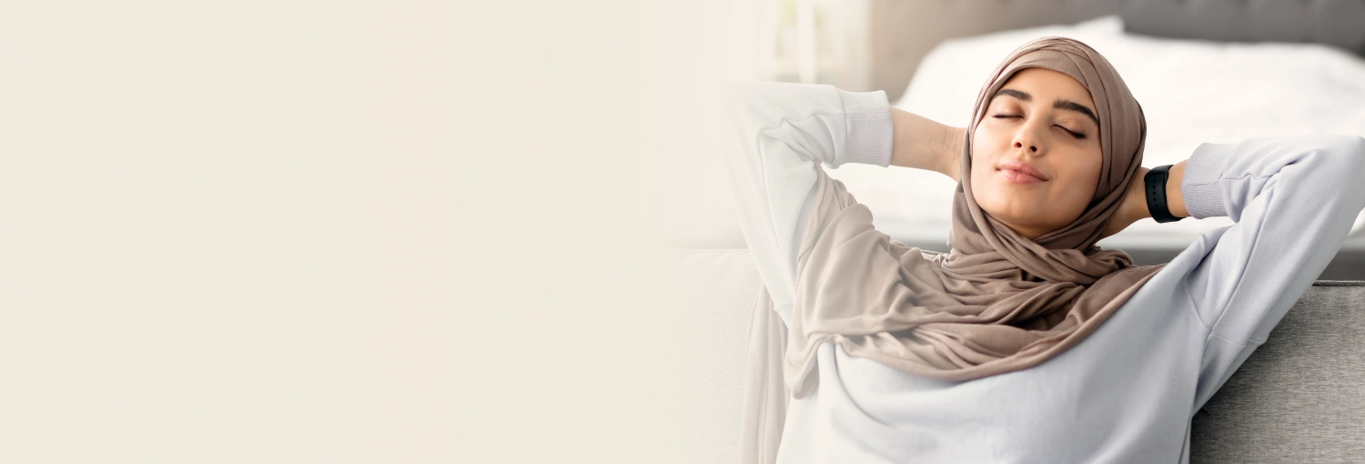 A woman resting in a chair with eyes closed and relaxing with a gentle smile