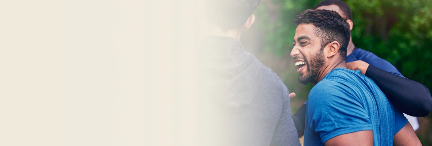 A man laughing with group of friends living his happy moments