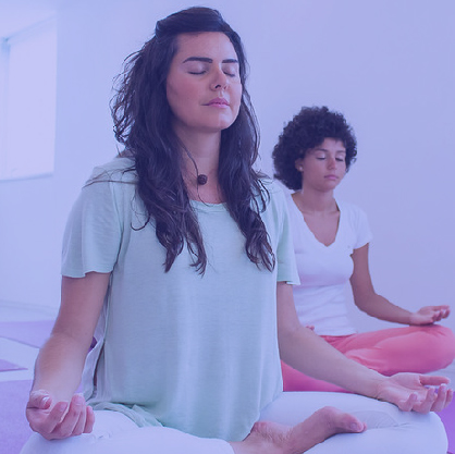 Uma mulher sorridente com os olhos fechados está a meditar
