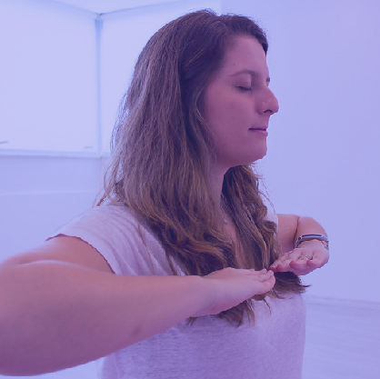 Um homem sorridente com as palmas das mãos viradas para baixo está a fazer exercício de respiração