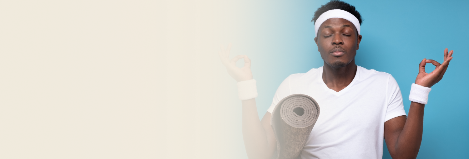 A young man sitting with eyes closed after the yoga session