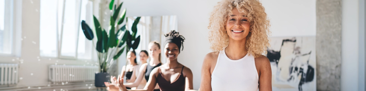 Group of women from different ethnicity sitting in a bright room after a meditation session