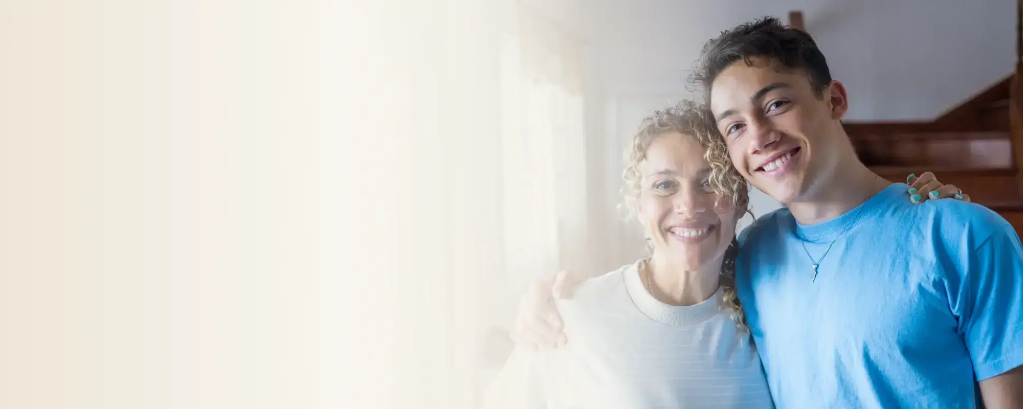 Ein lächelnder Teenager und eine Mutter symbolisieren eine glückliche, unterstützende Eltern-Kind-Beziehung.