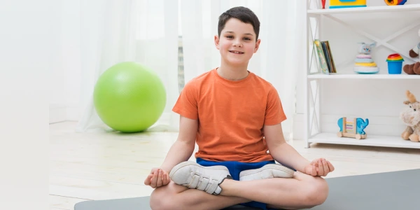 Giovane partecipante che pratica la postura di meditazione durante la sessione ART EXCEL in uno spazio di apprendimento consapevole