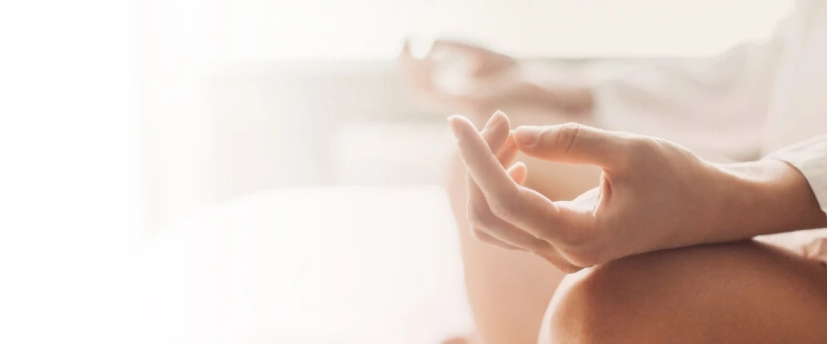 Close-up of a hand in a mudra, a symbolic gesture used in meditation, representing relaxation and mindfulness for deep sleep and anxiety relief
