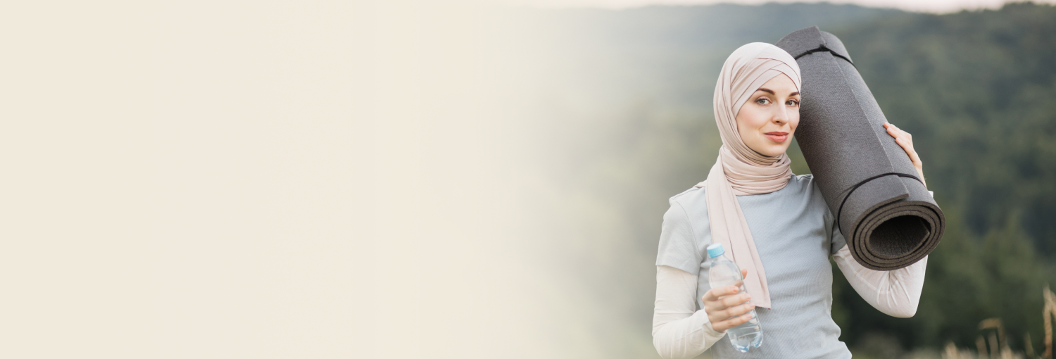 A woman in hijab holding a water bottle and a yoga mat