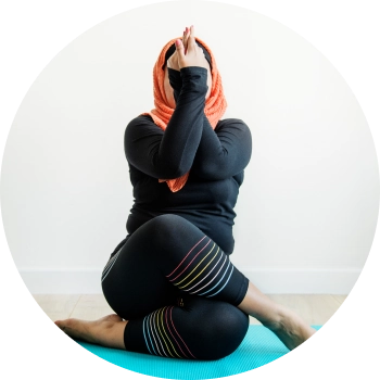 A woman performing yoga asana with crossed legs and twisted hands
