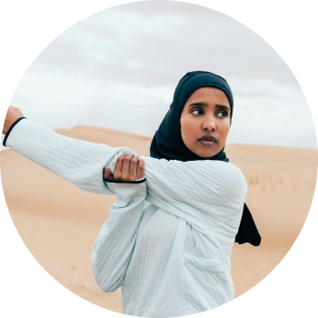 A woman standing in a dessert and stretching her hands