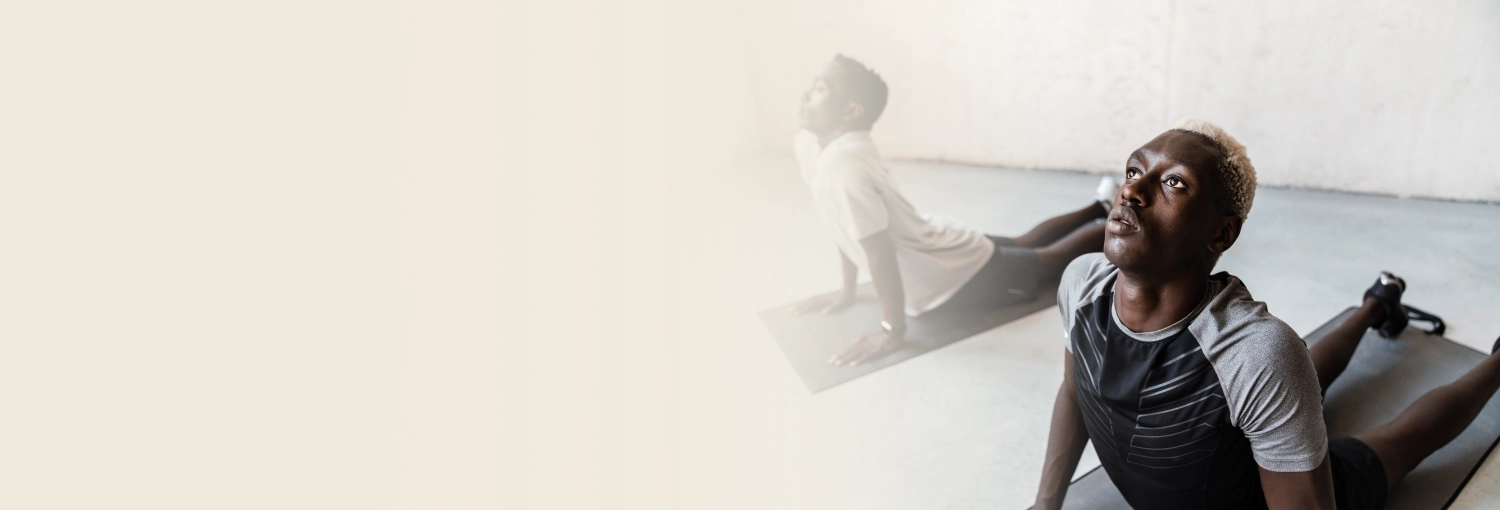 Two young African men performing yoga in a yoga studio