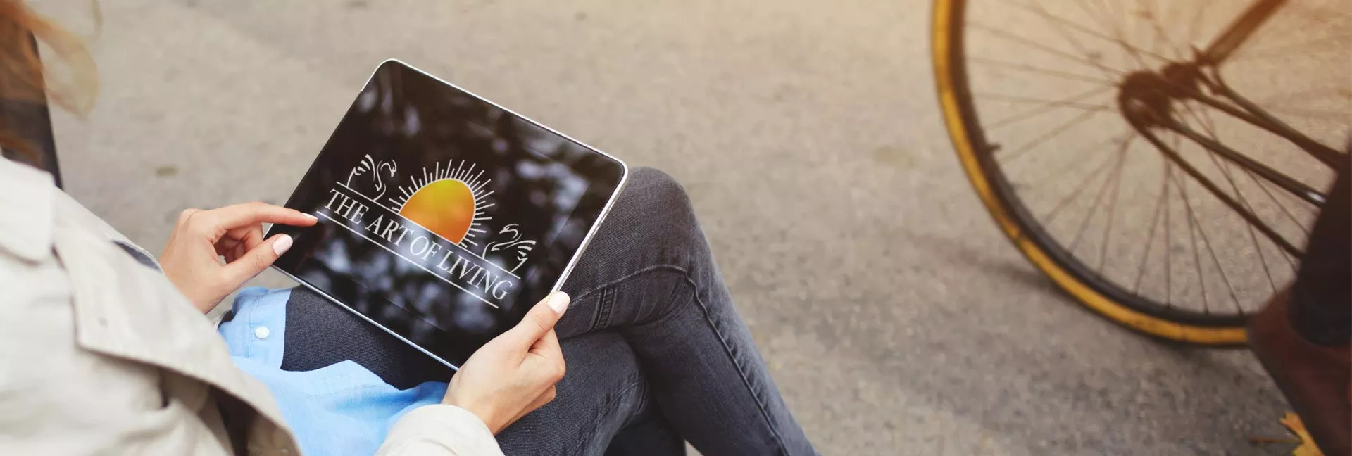 A women checking Art of living live events in a Ipad