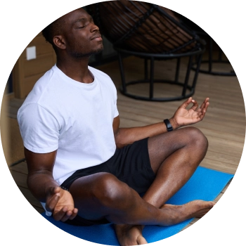 A young African man meditating with eyes closed and gentle smile in the face