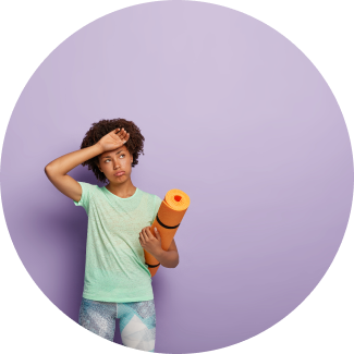 A young girl standing against a purple background with yoga mat in hand