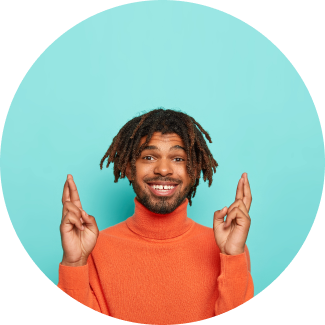 A man with braided hair showing crossed fingers depicting hope