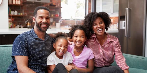 A family of four sitting on a couch and enjoying family time