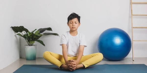 Young participant practicing meditation posture during ART EXCEL session in a mindful learning space