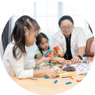 Teacher guiding four attentive children at a table, emphasizing life skills through ART Excel.