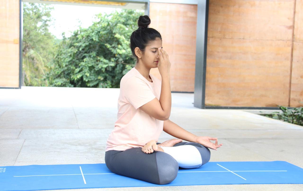 Lady sitting & doing Nadi Shodhan Pranayama