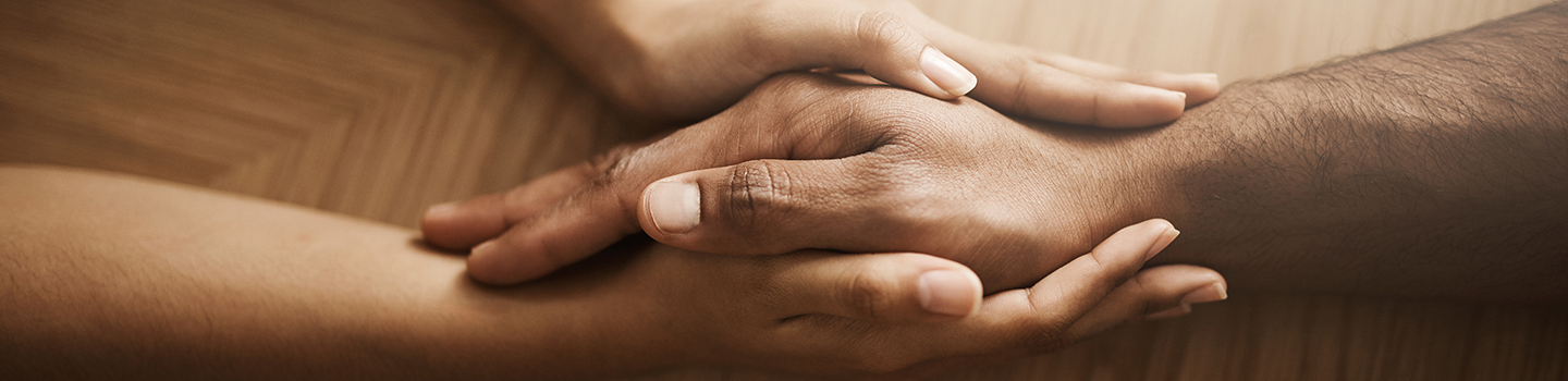 Close-up of two hands holding each other, symbolizing healing through blessings