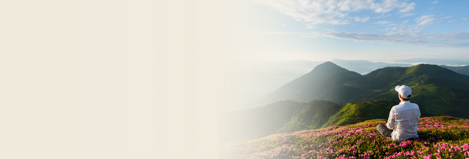 A young man sitting on a mountain valley and enjoying the serene view