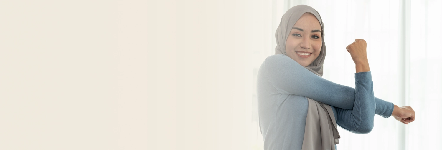 Smiling woman wearing a hijab stretching her arms