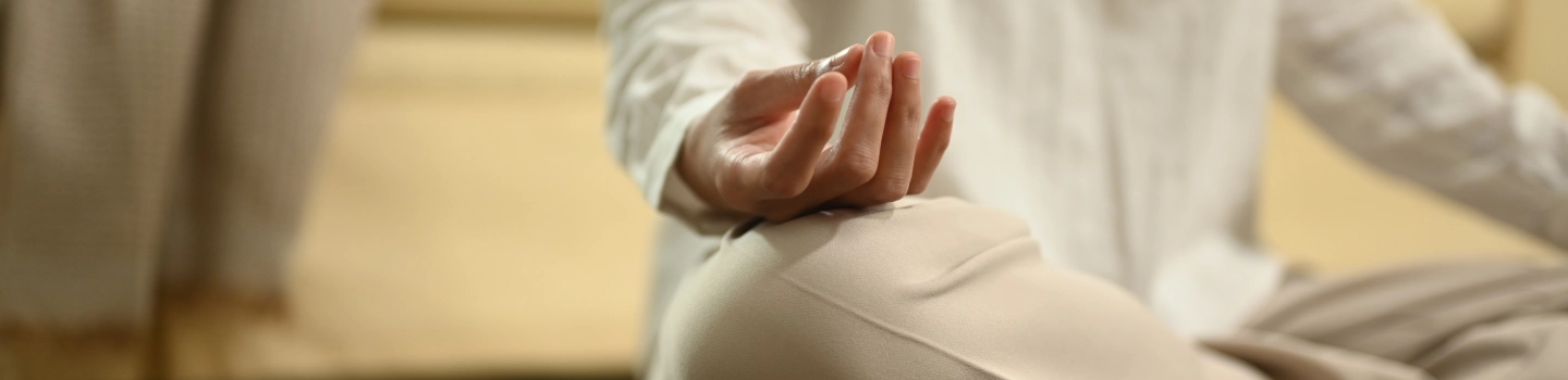 An image focused on hands of a person meditating in Shuni mudra