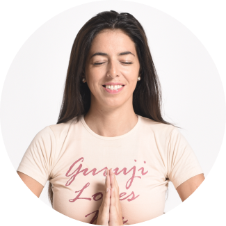 A young woman sits cross-legged on an open field, eyes closed in meditation