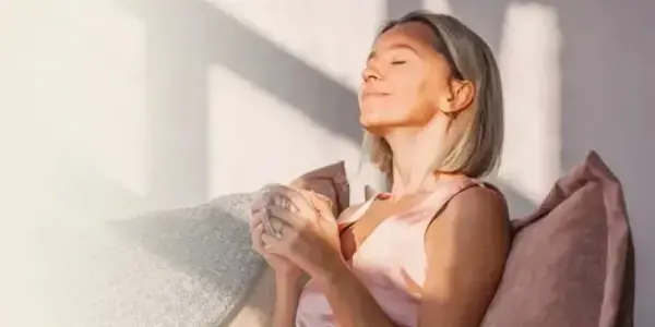 A woman resting peacefully on a chair with a serene expression, representing relaxation.