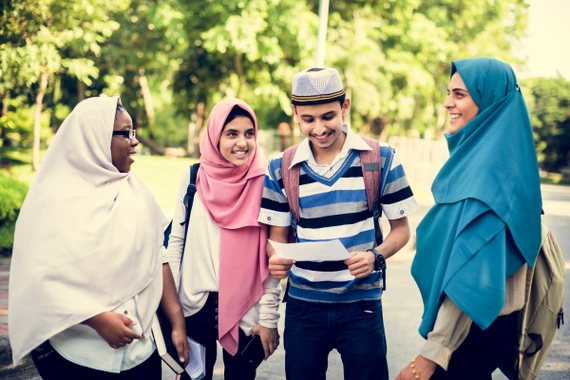 Four students standing outdoors after an introductory workshop, smiling and talking together