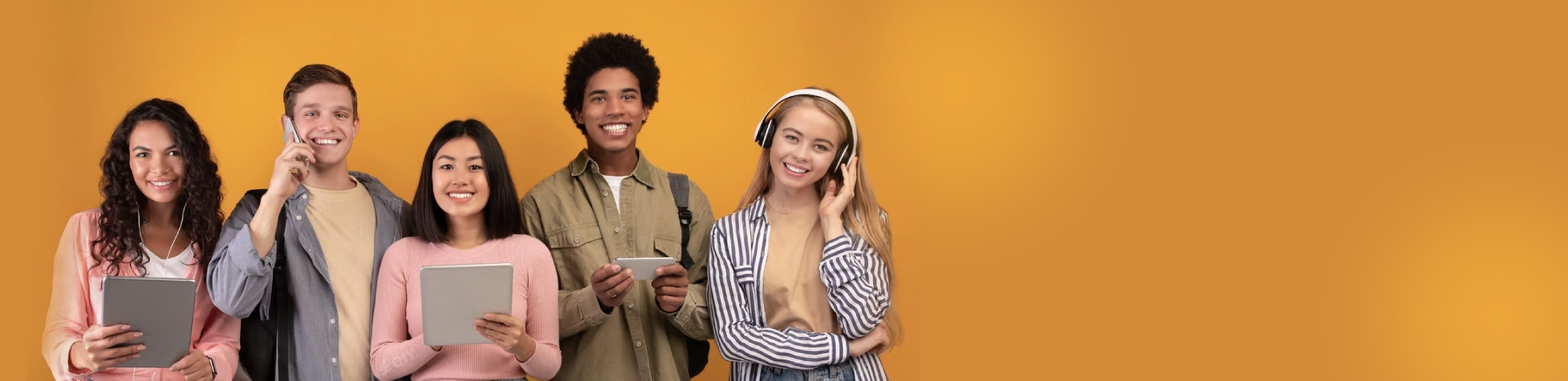 Grupė besišypsančių paauglių oranžiniame fone, kuriame užfiksuota linksma paauglių seminaro nuotaika.