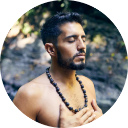 A smiling female with closed eyes meditating
