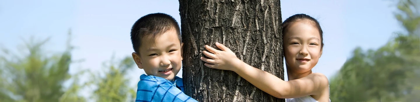 Two childern hugging a tree showcasing ART Excel life skills.