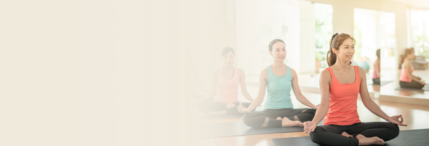 A smiling woman in a purple tank top performing the 'wai' greeting gesture.