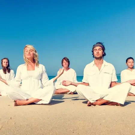 Enthusiastic group of Art of Living volunteers raising hands in unity during outdoor community service event