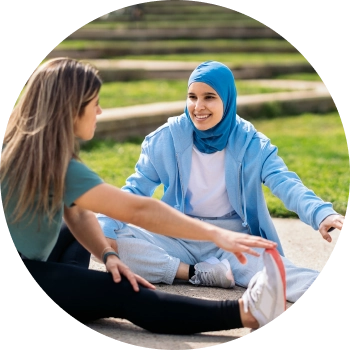 Two young girls stretching out their legs getting ready for a yoga session