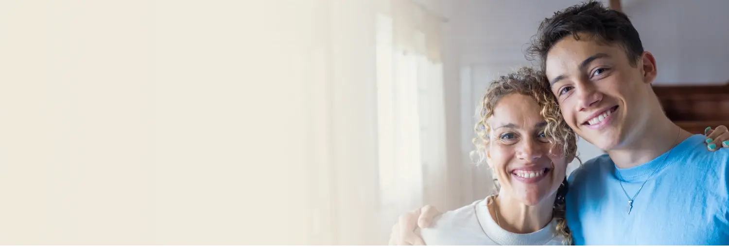 Mother and teen son smiling together, symbolizing a happy, supportive parent-teen relationship