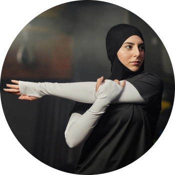 A woman in black hijab sports wear stretching her arms