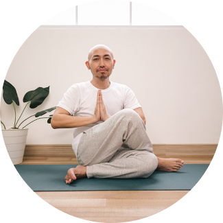 Young woman sitting cross-legged in meditation pose on grass practicing outdoor yoga