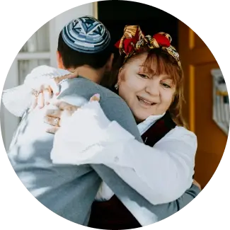 Woman with colorful headscarf hugging a child, representing warmth, kindness, and parent-child bonding