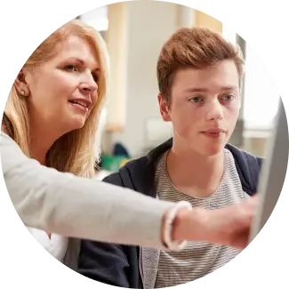 Mother guiding her teenage son as they look at a computer screen together, both focused on exploring career choices